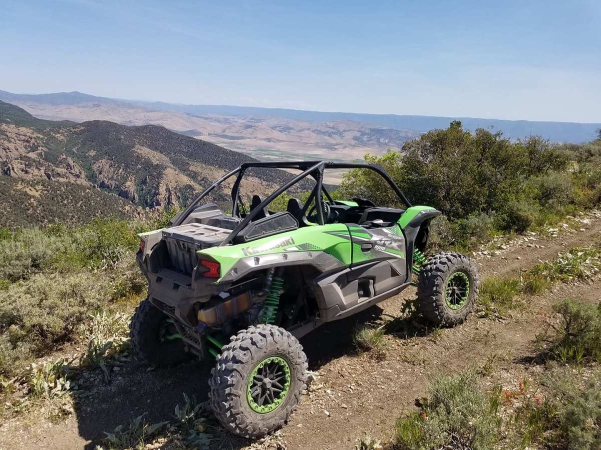 Kawasaki Teryx KRX 1000 off-road vehicle parked on rugged trail with scenic mountain background showcasing Kawasaki Teryx KRX 1000 accessories and upgrades