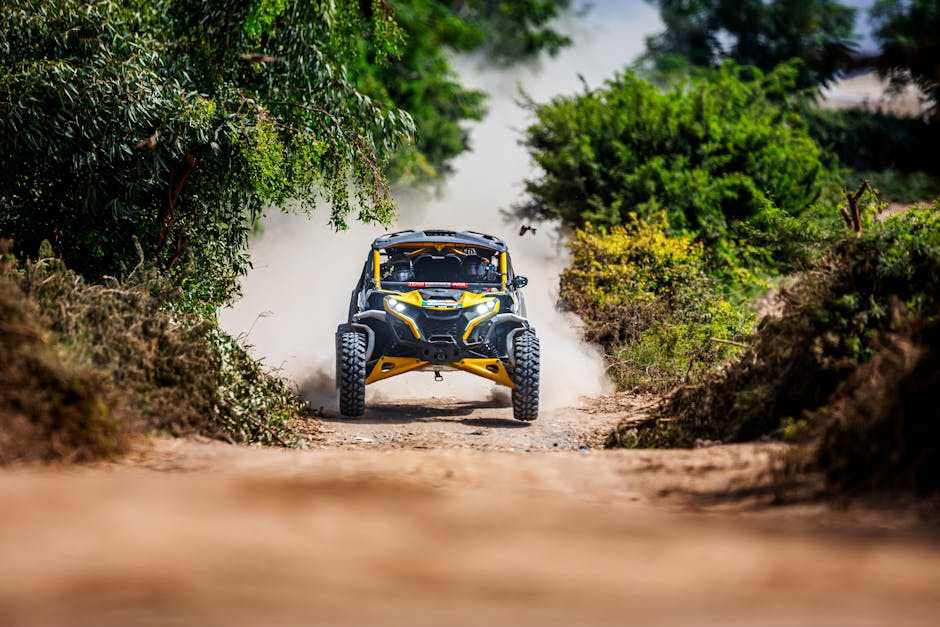 Can-Am off-road vehicle speeding on rugged dirt trail surrounded by trees and dust