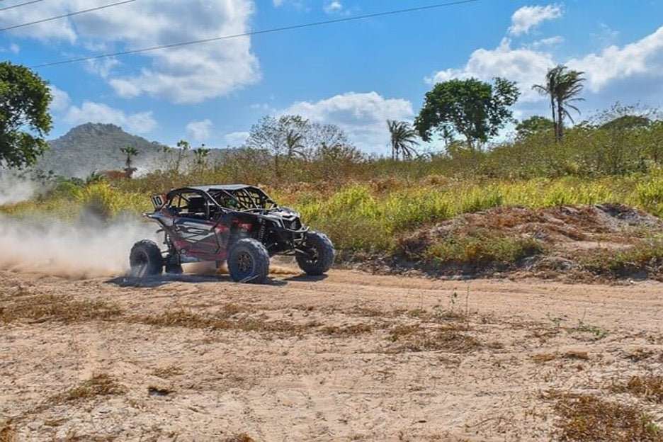 Offroad UTV driving on dirt trail under blue sky with trees and hills in background street legal UTV concept