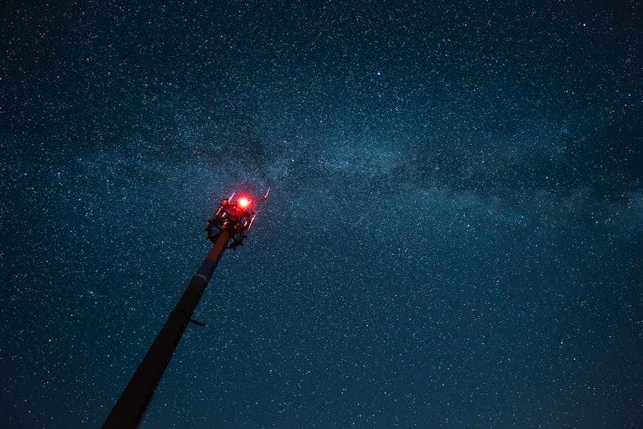 Night sky with stars and a communication tower transmitting signals, representing handheld GMRS radios for overlanding connectivity