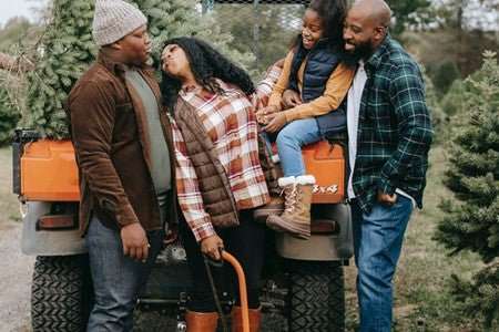 Family enjoying outdoor adventure near side-by-side UTV in forest setting