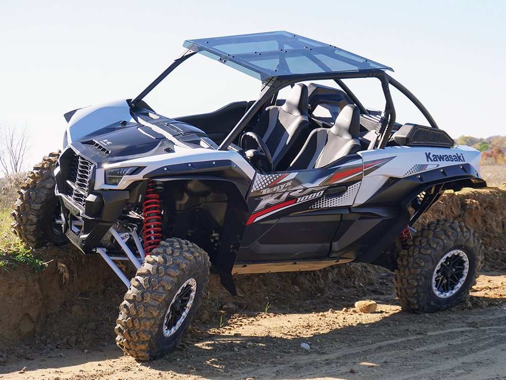 Kawasaki UTV off-road vehicle with rugged tires and protective accessories on dirt trail