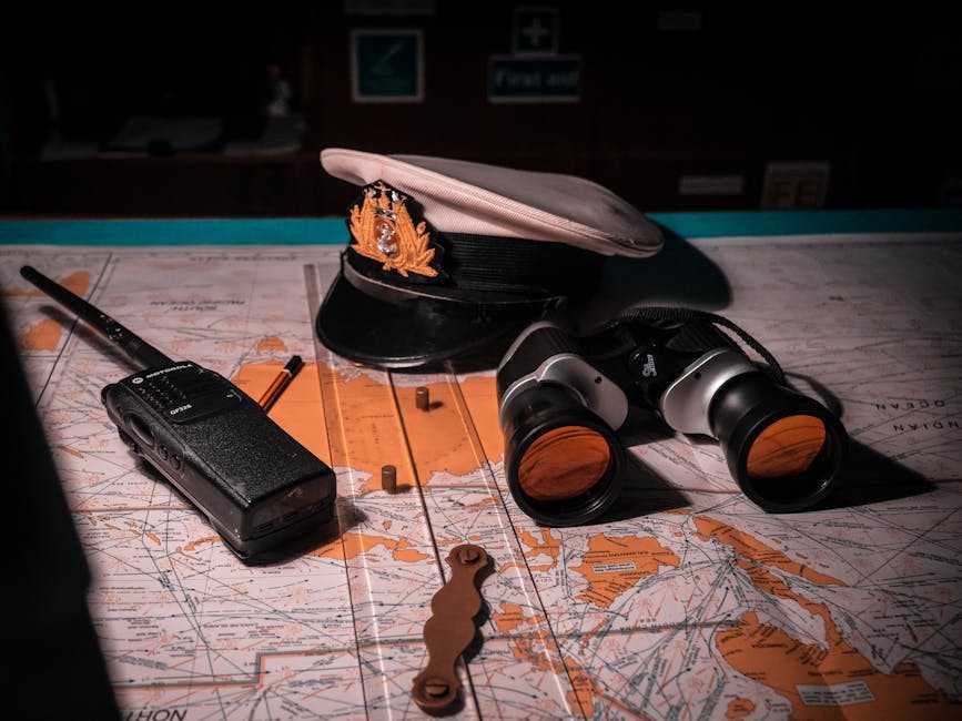 Cobra MR HH450 marine radio with captain's hat and binoculars on nautical map for boating navigation and communication