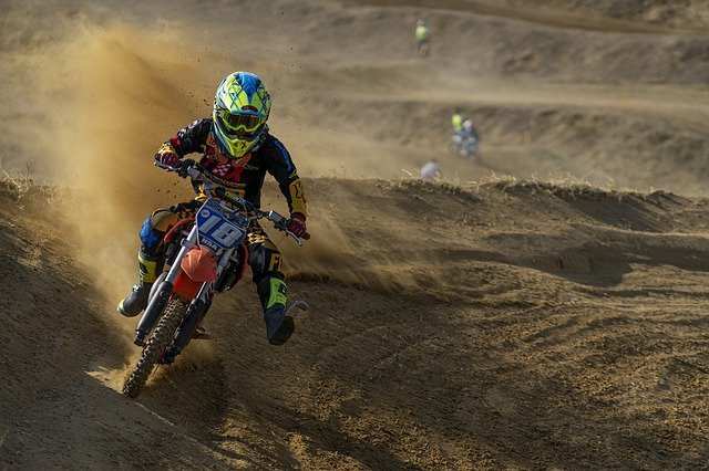Motocross rider racing on dirt track showcasing motocross off-roading sport.