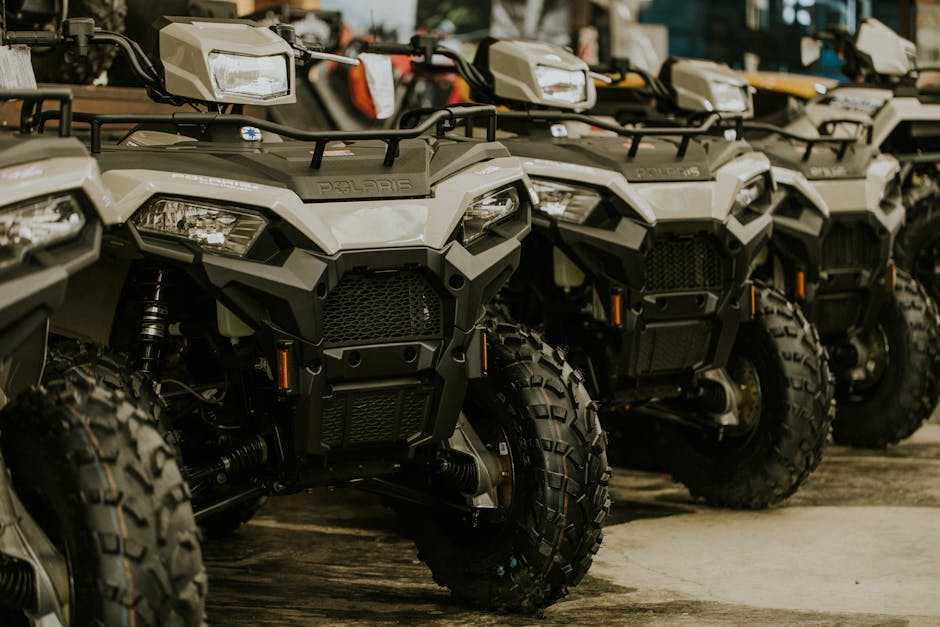 Row of rugged Polaris off-road vehicles showcasing durable design with focus on front grills and tires for quality Polaris accessories promotion