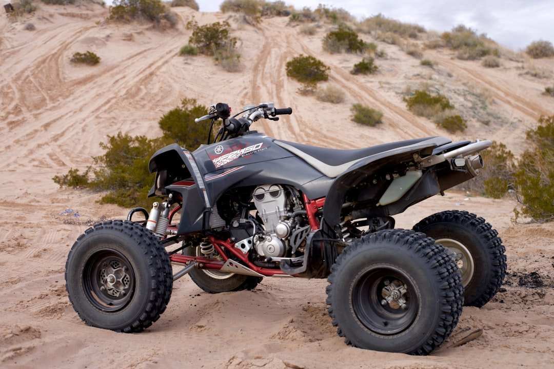 Polaris ATV with durable tires parked on sandy terrain for off-road riding and Polaris parts online enthusiasts
