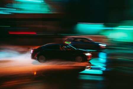Black sports car drifting at high speed demonstrating double clutching technique in racing